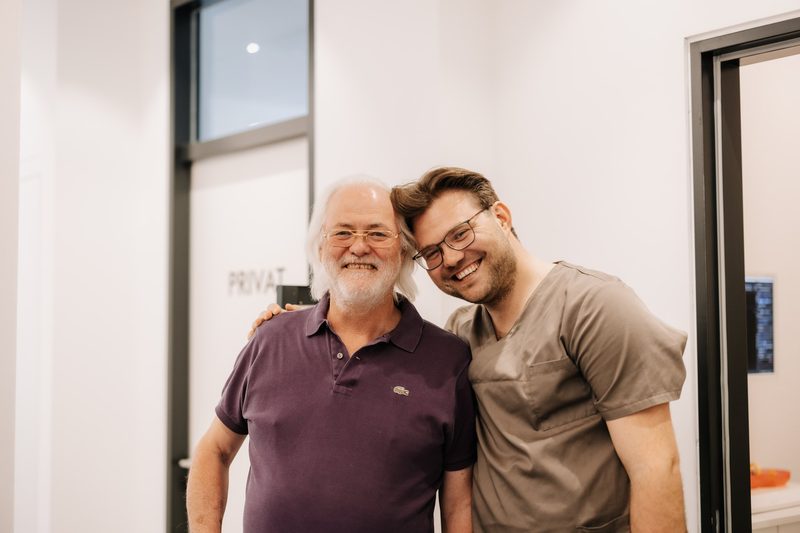 Dr. Harald Hermanns und Dr. Stefan Hermanns lachend in der Praxis