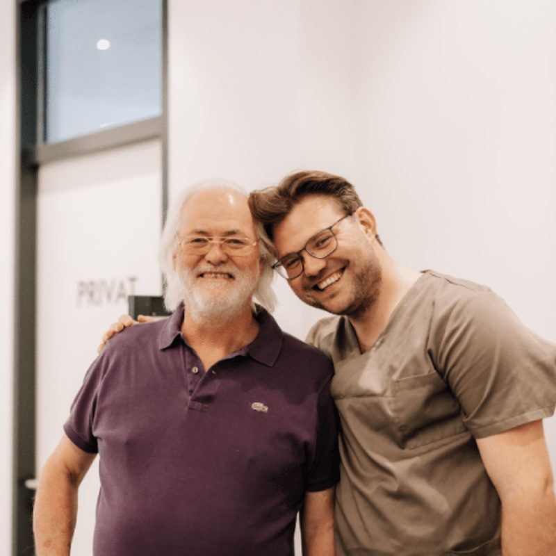 Dr. Harald Hermanns und Dr. Stefan Hermanns lachend in der Praxis