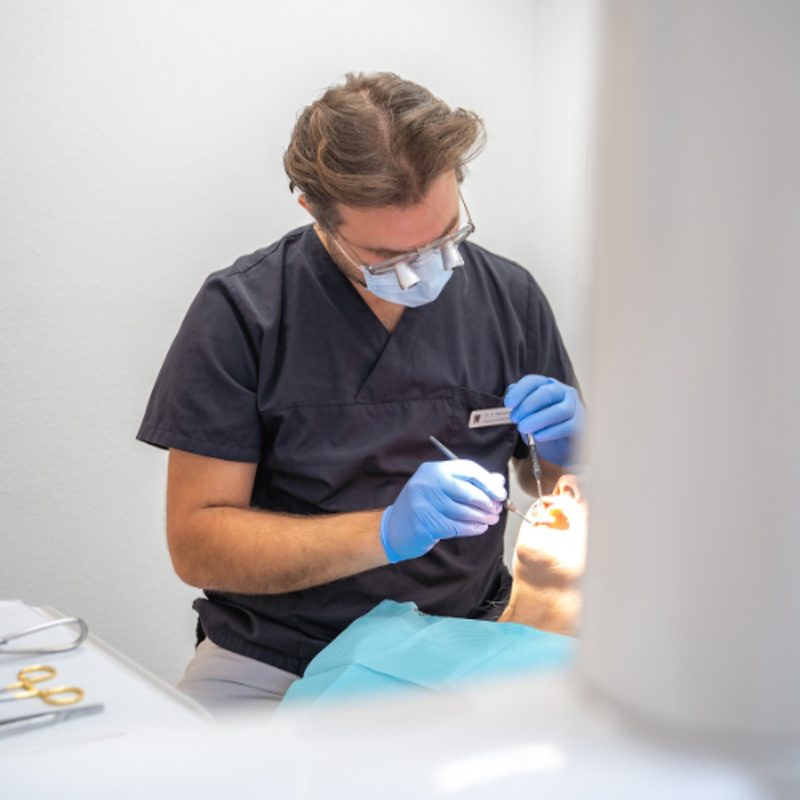 Zahnarzt bei der Behandlung mit Lupenbrille